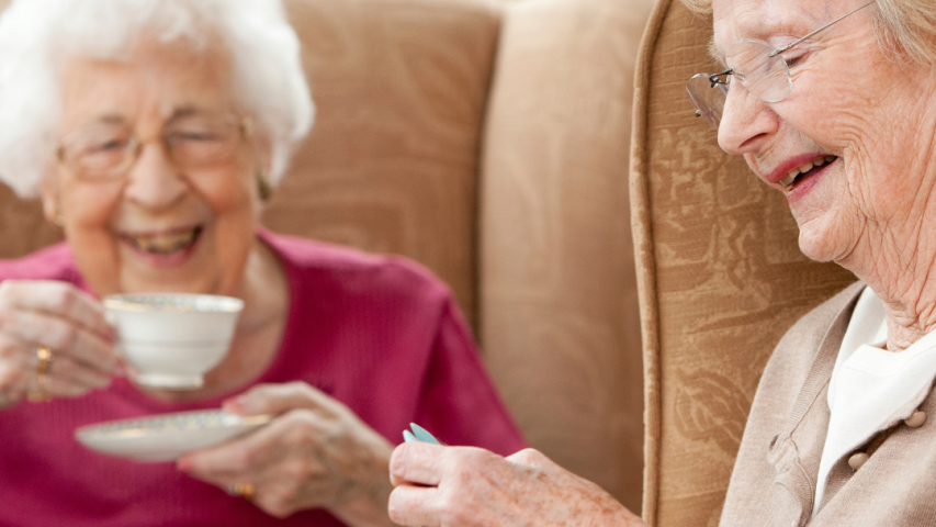 Deux dames âgées, l'une tricote, l'autre boit une tasse de café